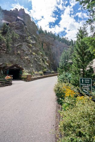A Road With A Sign On It And A Mountain In The Background