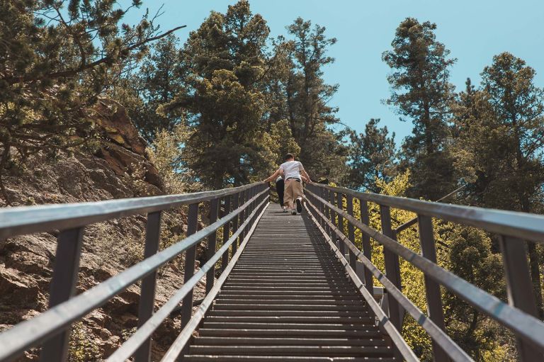 A Person Walking On A Wooden Bridge