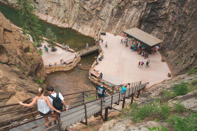 People Sitting On A Wooden Bridge Over A River