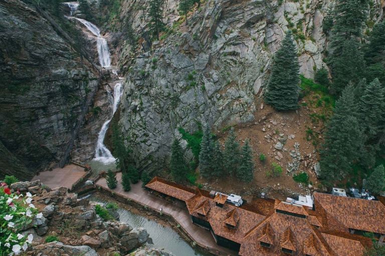 A Building With A Waterfall And Trees