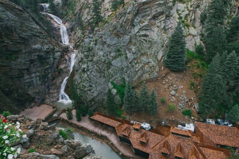 A Building With A Waterfall And Trees