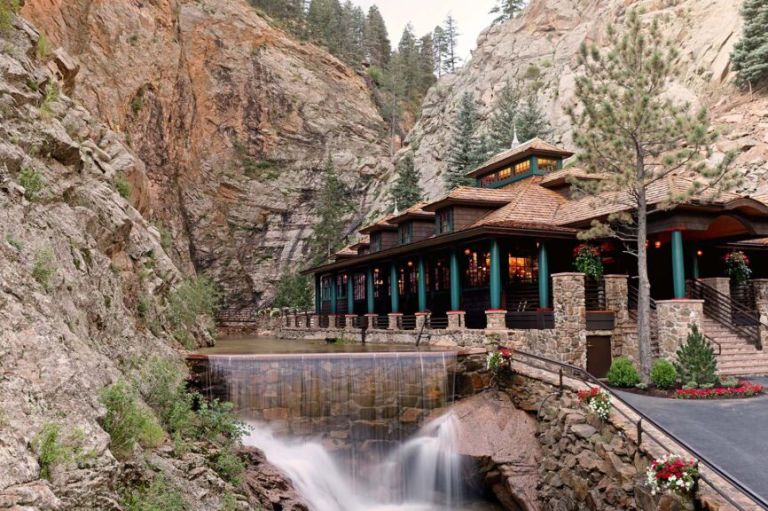 A House With A Waterfall And A Pond In Front Of It